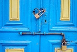 A set of padlocked old blue and yellow doors.