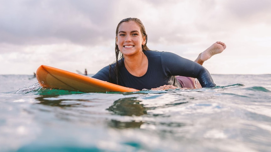woman on surf board smiling