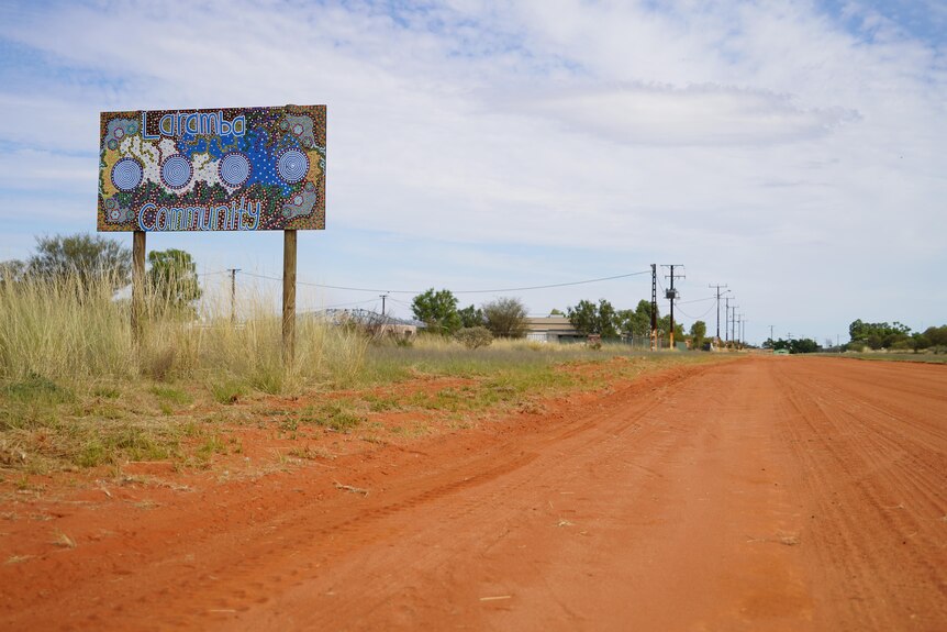 A sign near a red dirt road