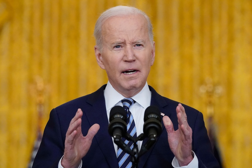 US President Joe Biden speaks at a lectern.