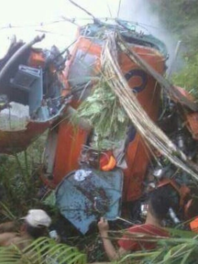 People look at the wreck of a helicopter in Indonesia's mountains.