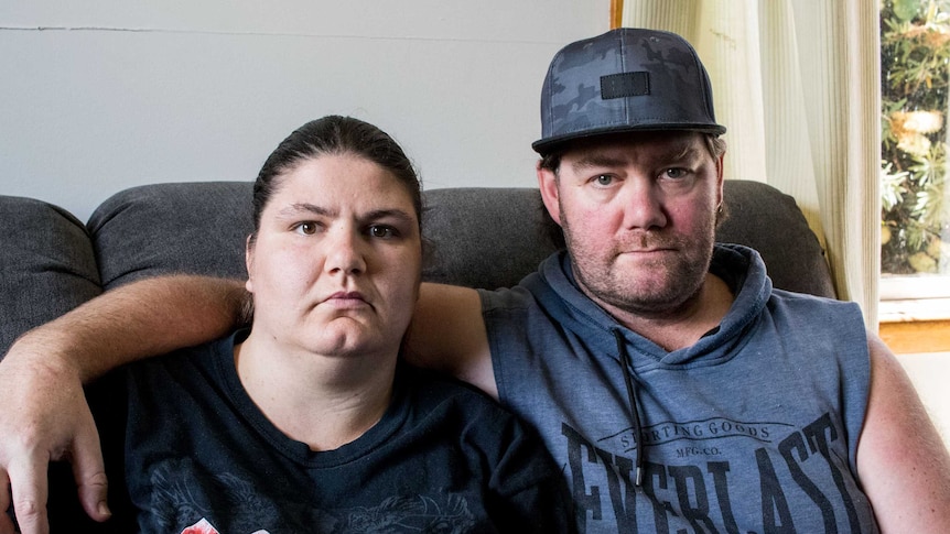 Bronwyn Carrick and Steven De Boer sit on a couch. Steven's arm is around Bronwyn.