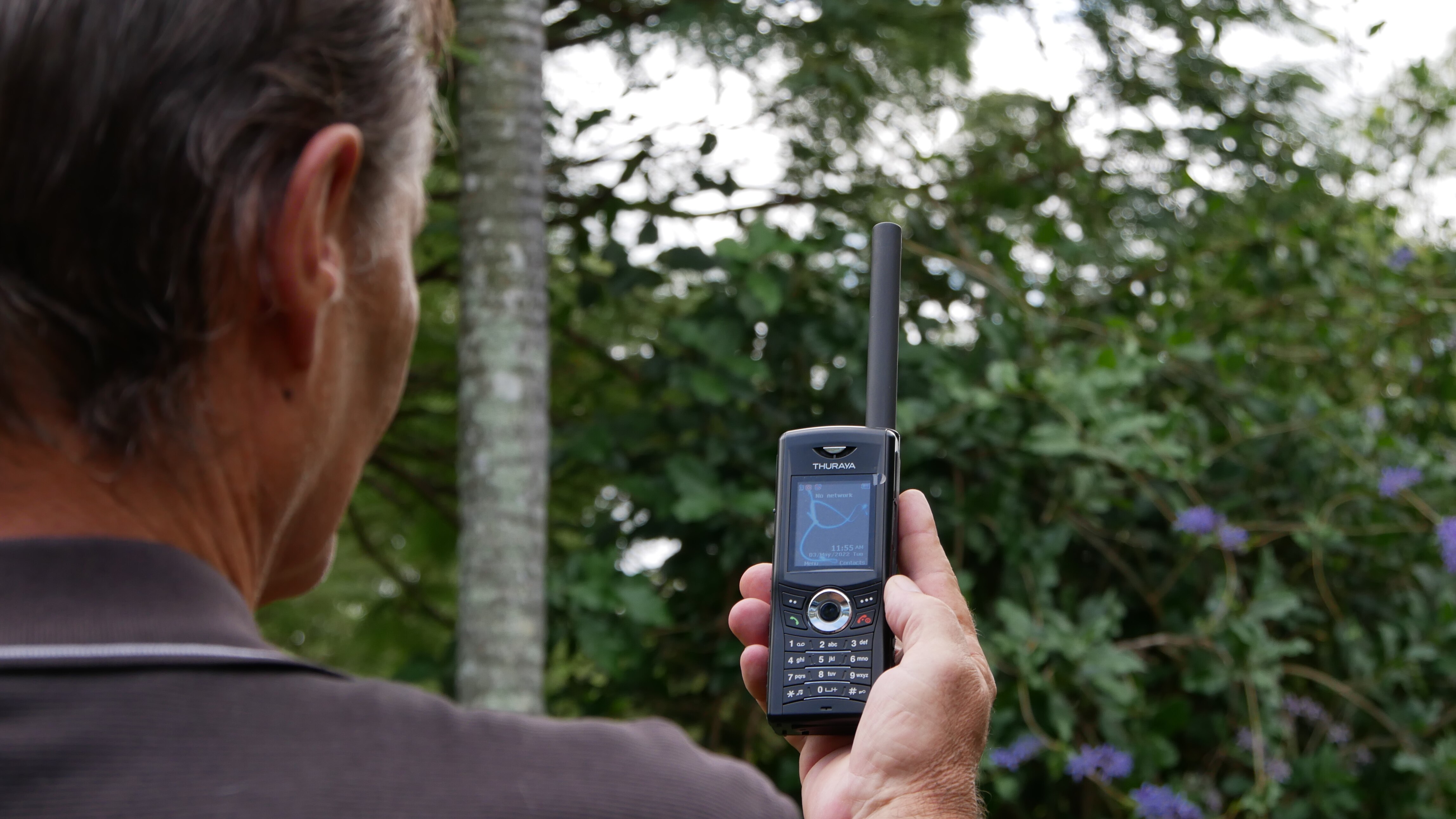 A man holds up a satellite phone