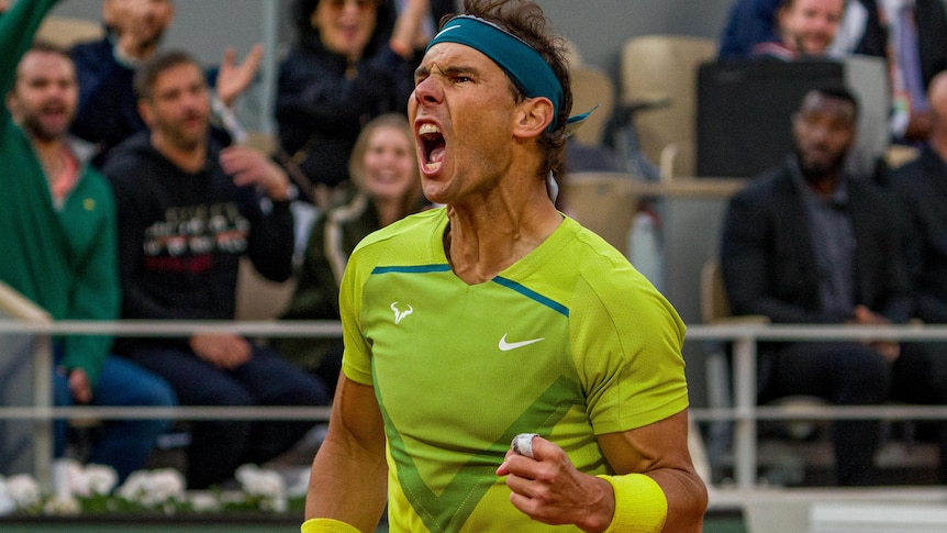 Rafael Nadal fist pumps and screams as he wins a point against Felix Auger-Aliassime at the French Open