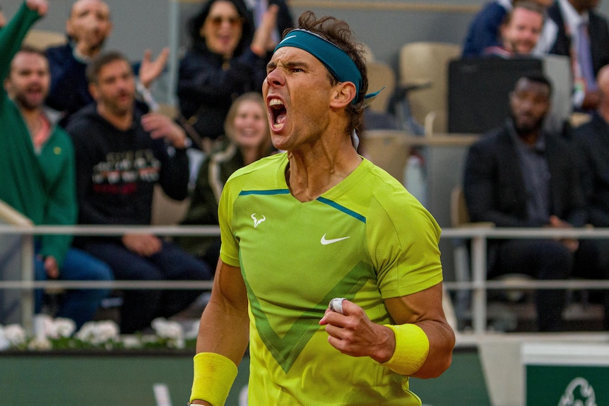 Rafael Nadal fist pumps and screams as he wins a point against Felix Auger-Aliassime at the French Open