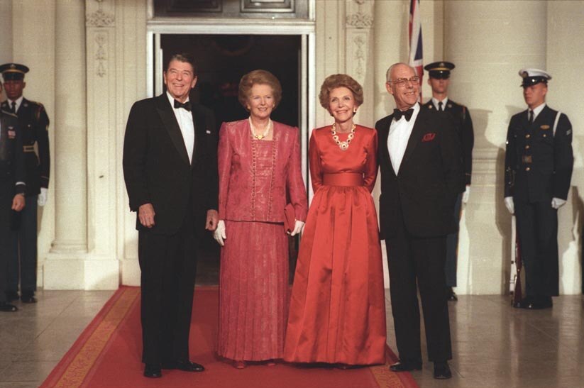Left to right: Ronald, Margaret, Nancy and Denis. The women both wear red gowns and the men wear suits with bow ties.
