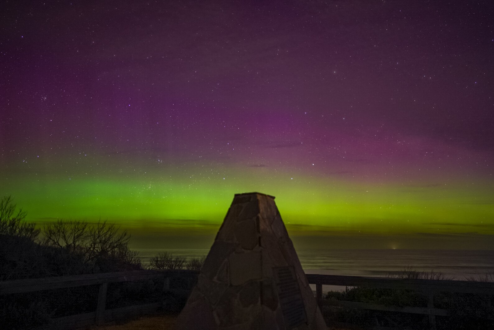 Um brilho verde e roxo sobre Barwon Heads Bluff
