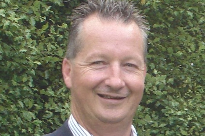 a man in a suit smiling at the camera