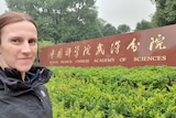 A woman stands next to a sign that reads 'Wuhan Branch, Chinese Academy of Sciences'