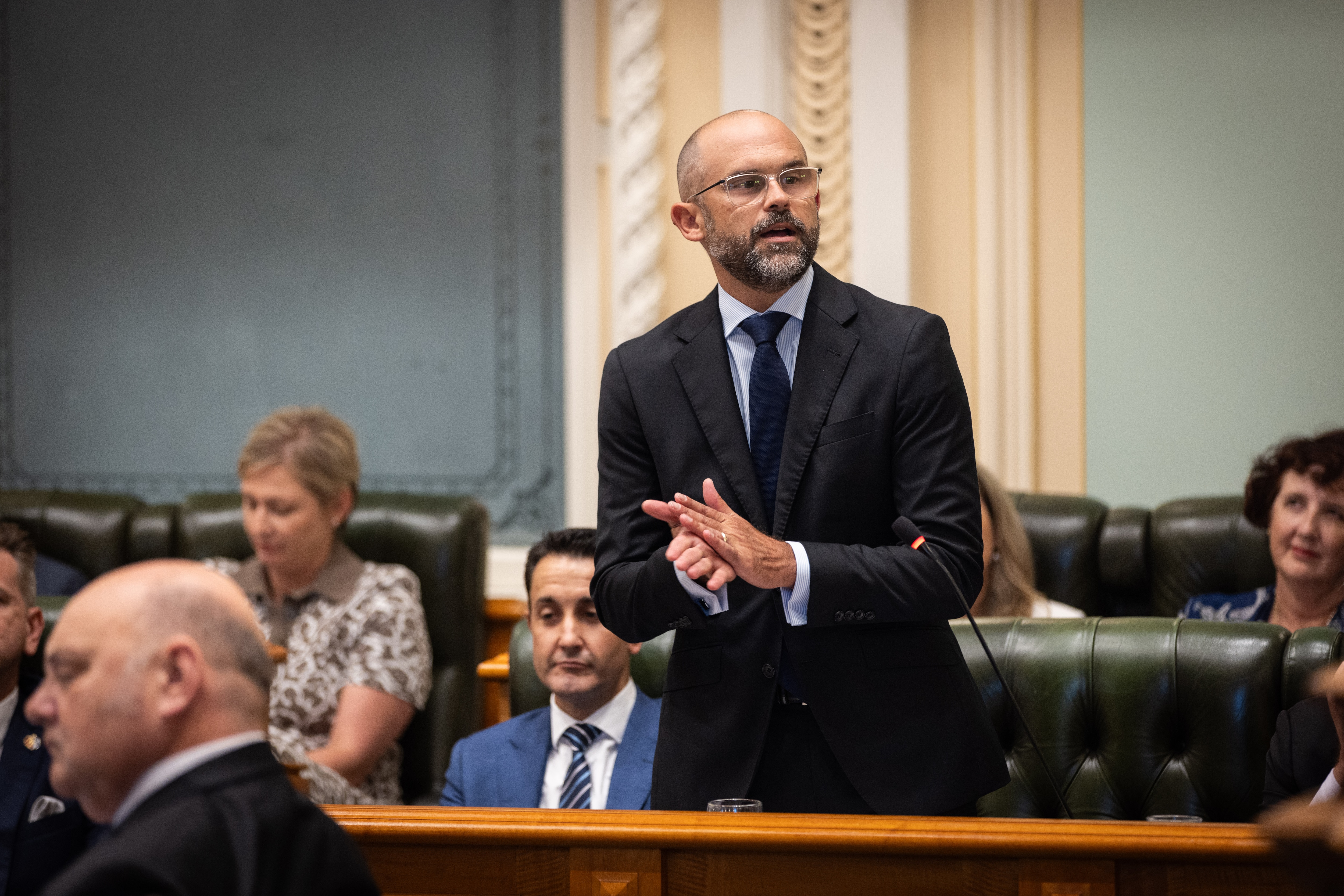 A man in a grey suit speaking in Queensland's state parliament.