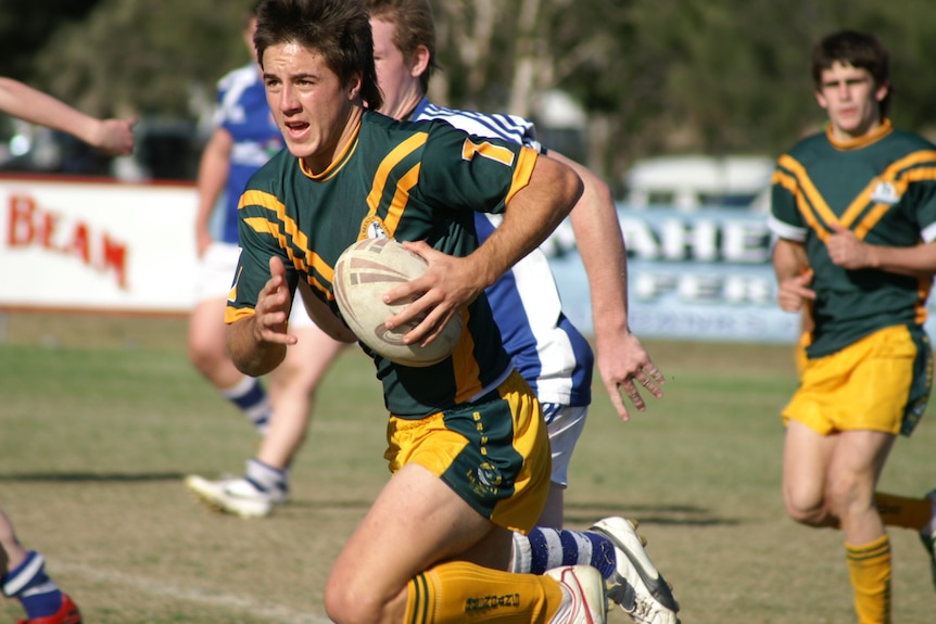 Ben Hunt courant avec le ballon, uniforme vert de St Brendan.