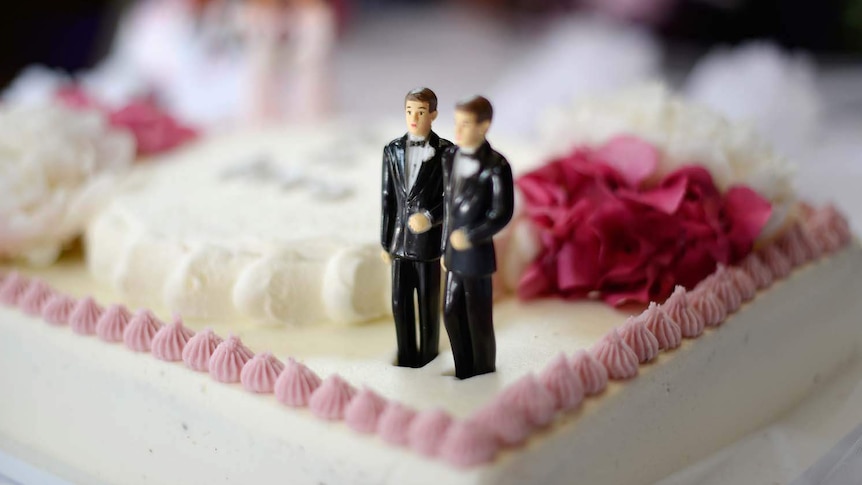 Figurines of two grooms on a wedding cake