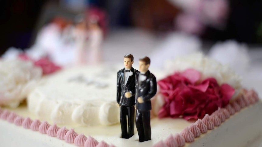 Figurines of two grooms on a wedding cake