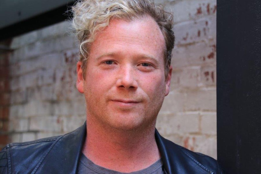 A head and shoulders shot of Matty Wright wearing a leather jacket posing for a photo.