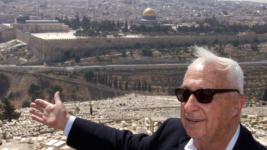 Opposition leader Ariel Sharon of the right-wing Likud gestures towards Jerusalem's Old City.
