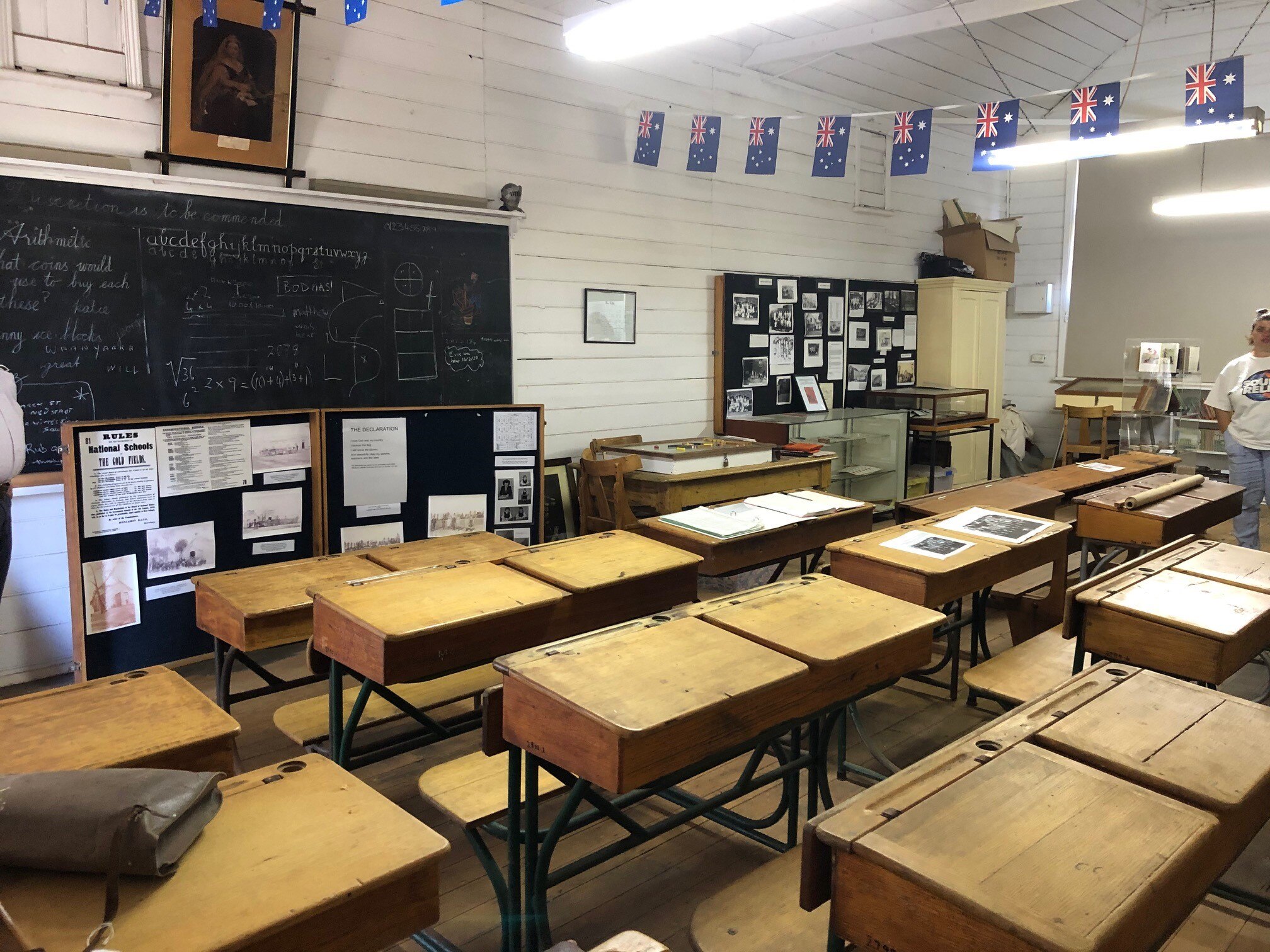 The historic portable class room with wooden school desks and blackboard. 