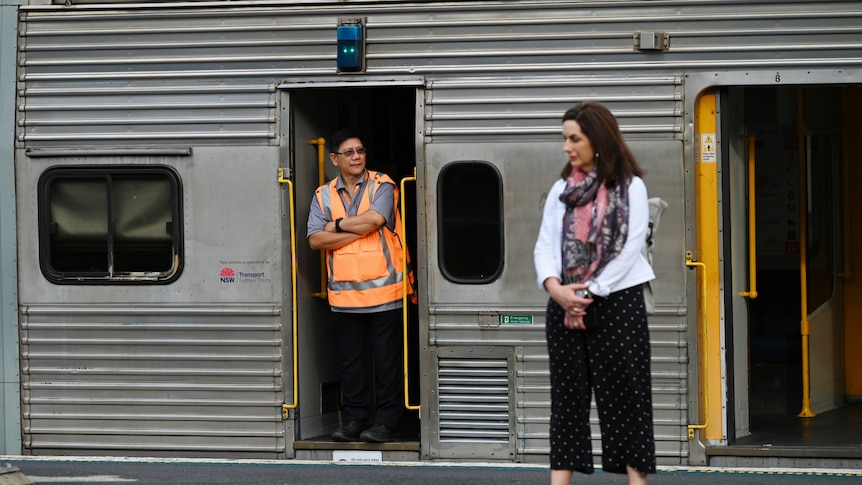 a rail guard standing in a train at a railways station