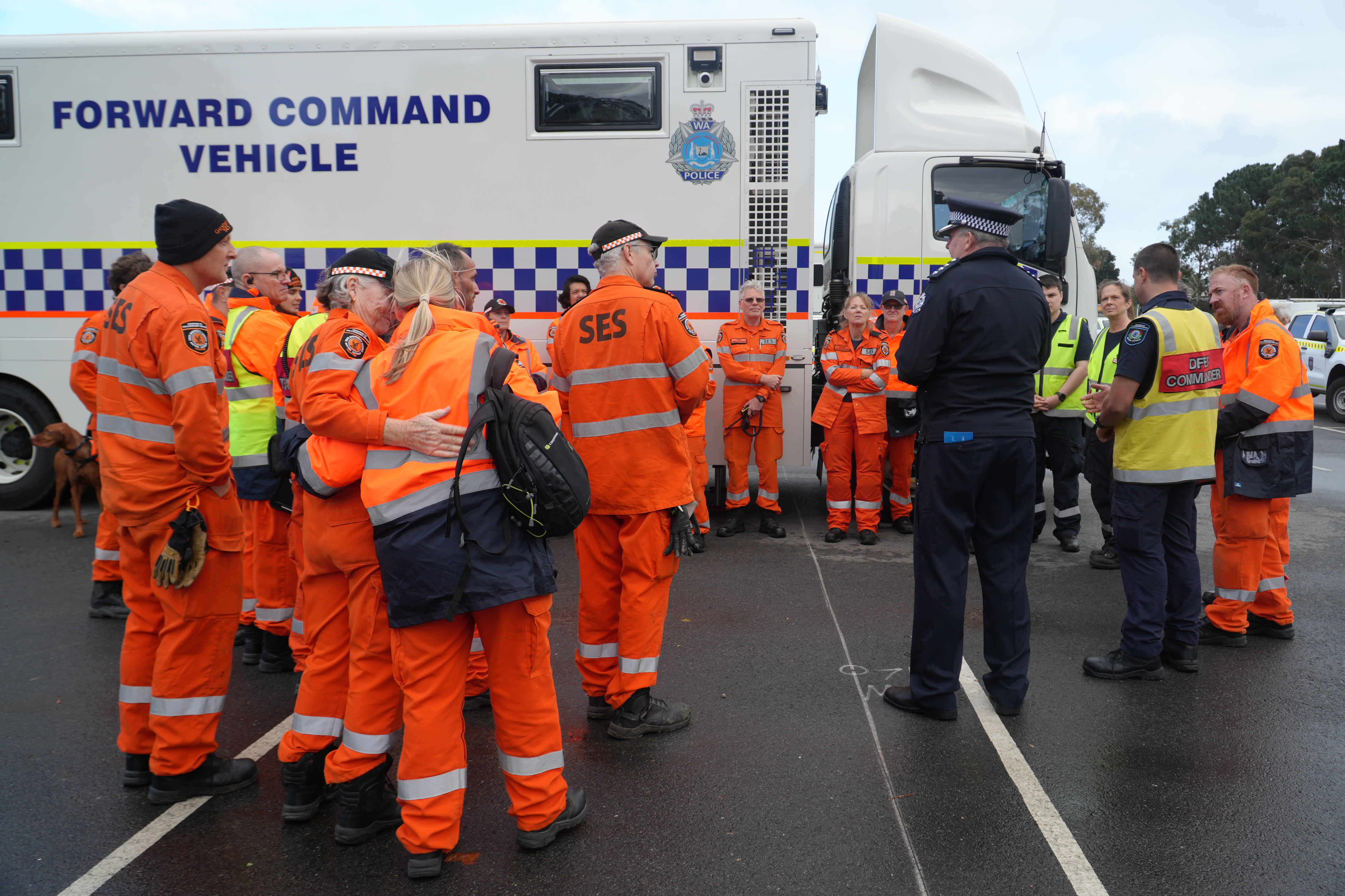 People in bright orange SES uniform standing around 