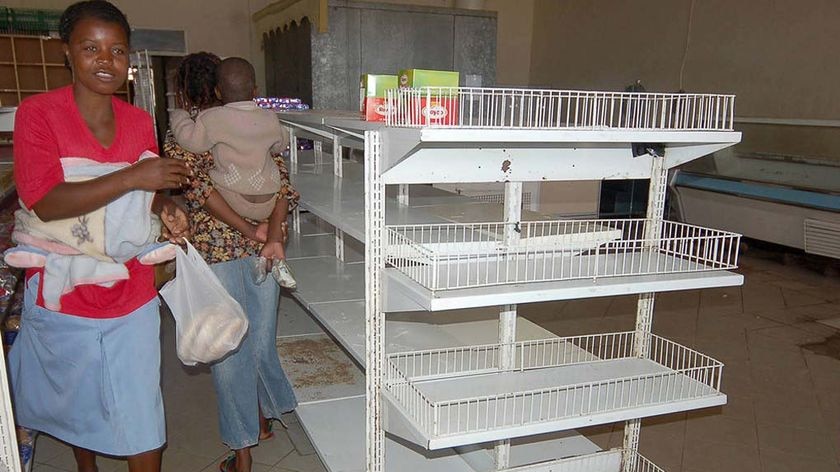 Zimbabwean shoppers walk past empty shelves in a supermarket in Harare.