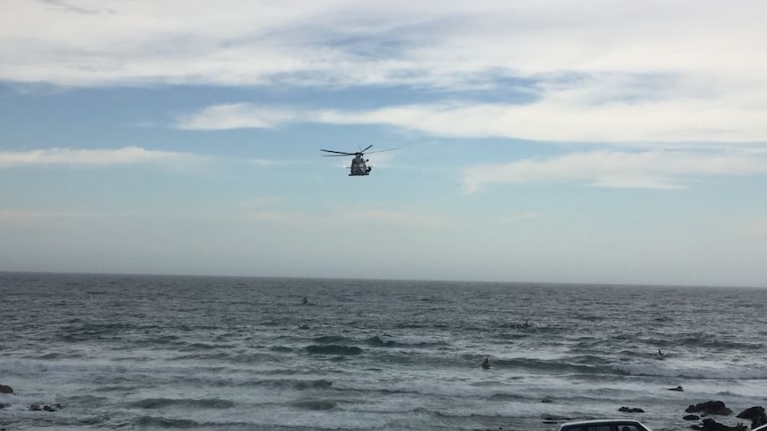 A rescue helicopter flies over Flynn's beach at Port Macquarie.