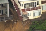 A house with a corner wall missing due to erosion.