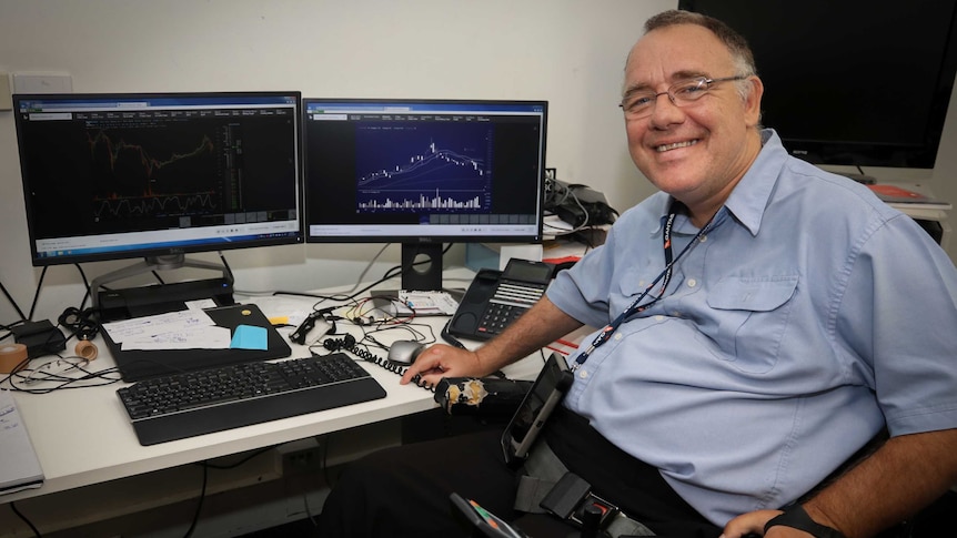 man in wheelchair in front of computer screens