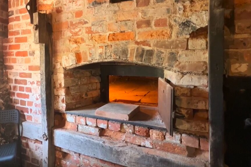 An old-style, brick, woodfired ovem with an arched opening.