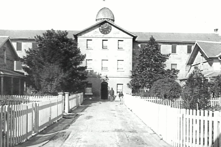 A black-and-white shot of a 19th century institutional building.