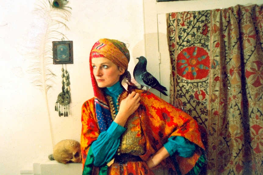Amanda Feilding wears poses with a pigeon on her shoulder.