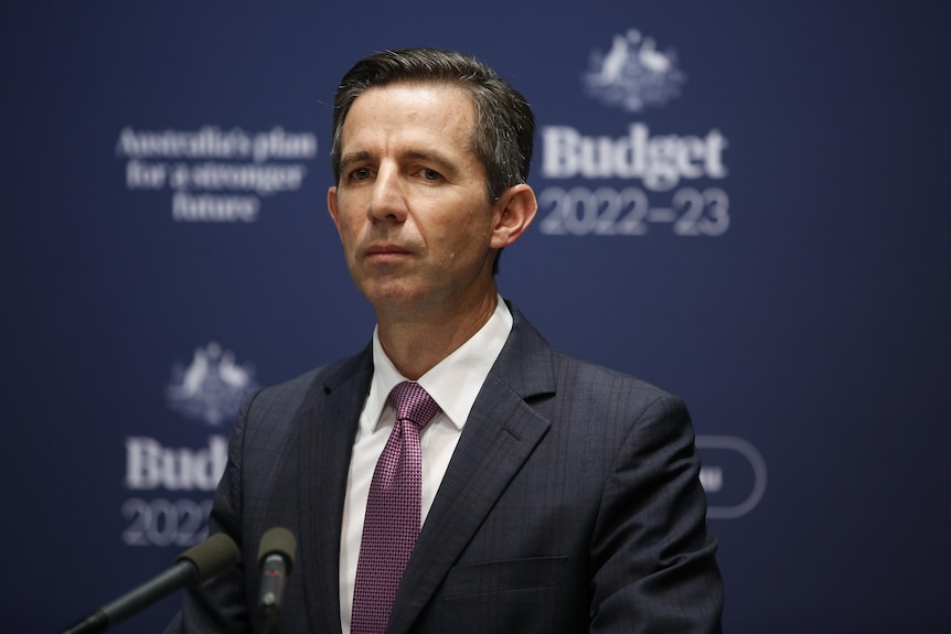 Simon Birmingham stands in front of budget 2022-23 branding