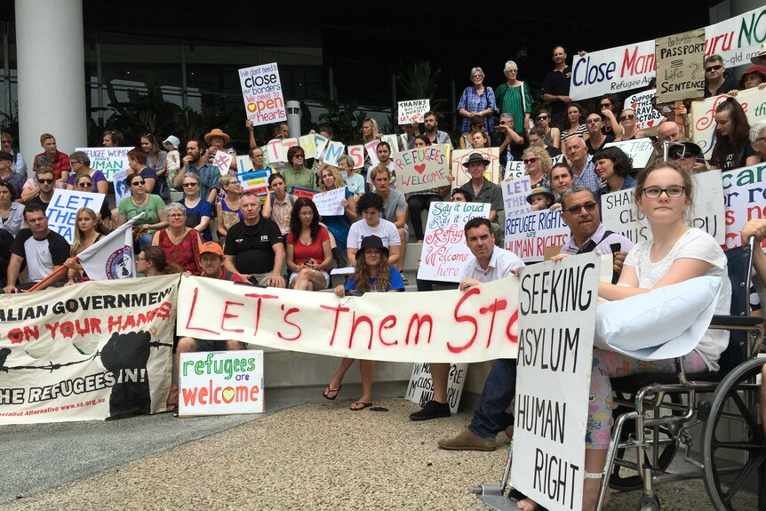Protestors hold signs in protest at Lady Cilento Children's Hospital