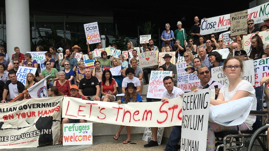 Protestors hold signs in protest at Lady Cilento Children's Hospital