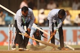 Groundskeepers sweep the pitch for the third Test between Australia and India in Indore.
