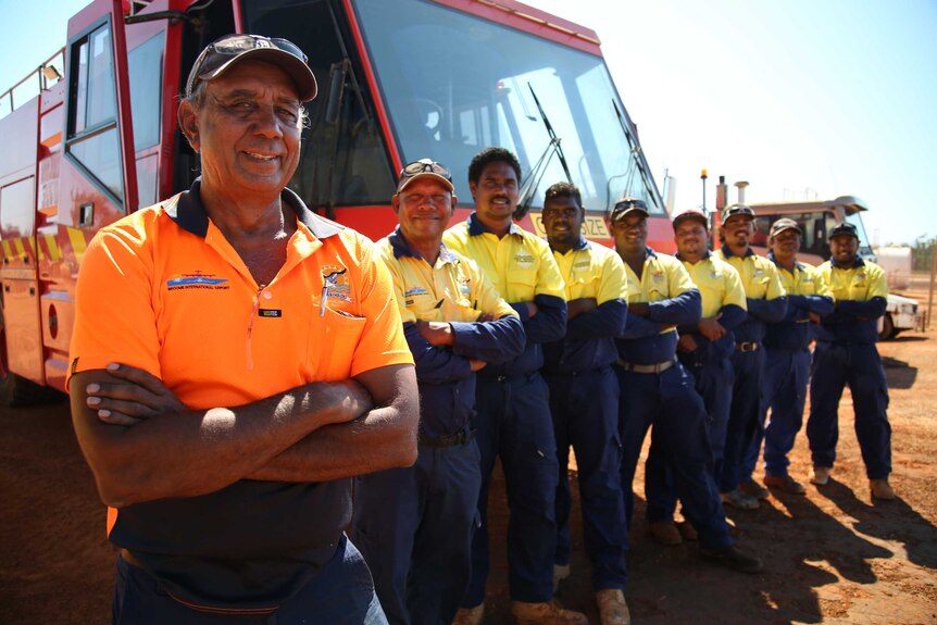 Kimberley Baird stands with members of the refuelling team in front of a truck.
