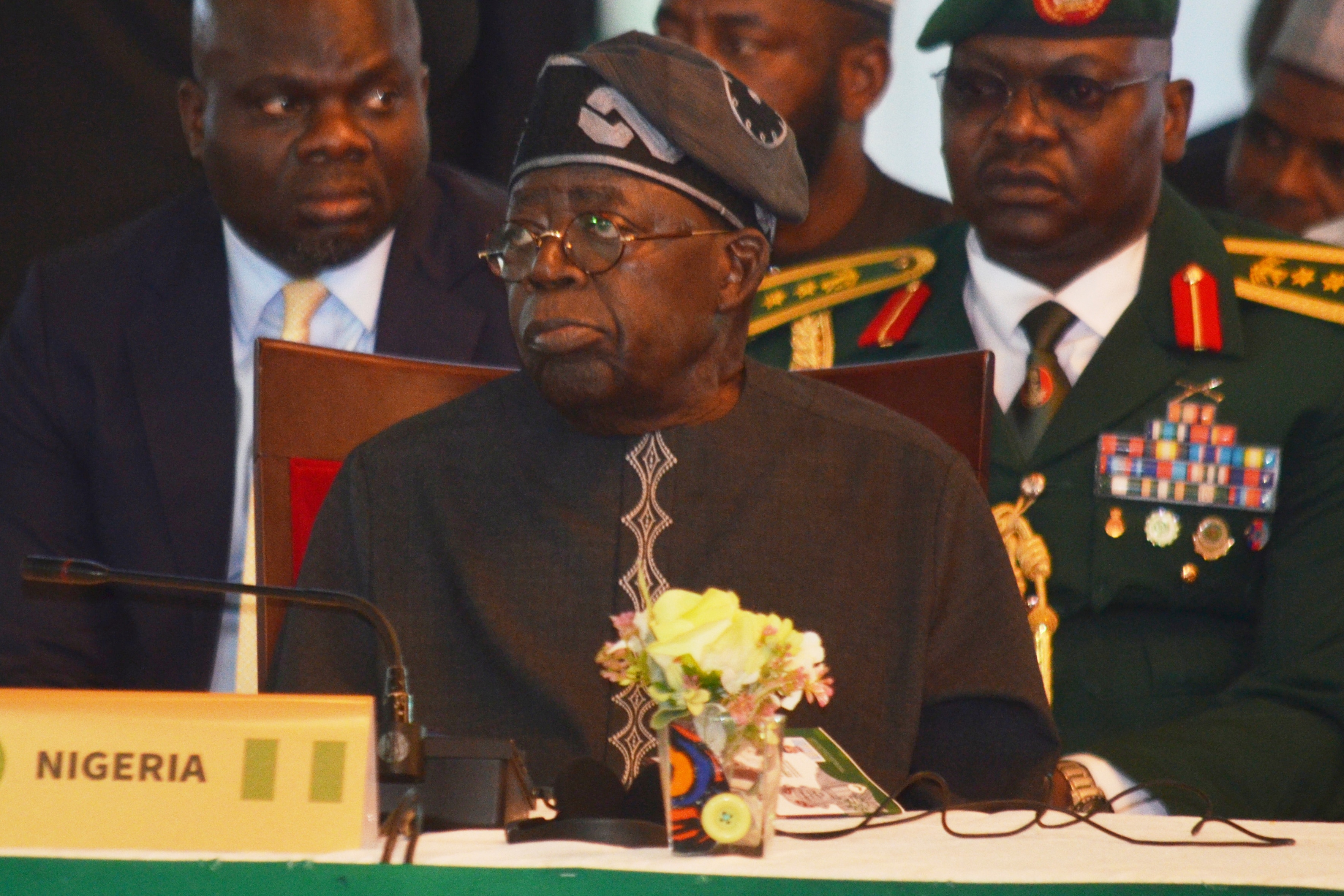 Bola Ahmed Tinubu lleva una tarjeta de lugar negra "Nigeria" frente a él.