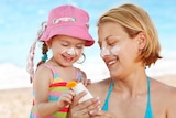 Mother and daughter applying sunscreen