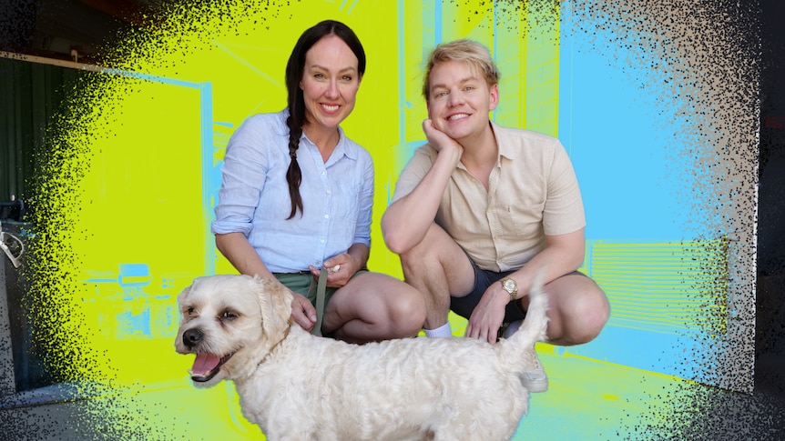 ABC TV hosts Laura and Joel smile, crouching next to a fluffy white dog.