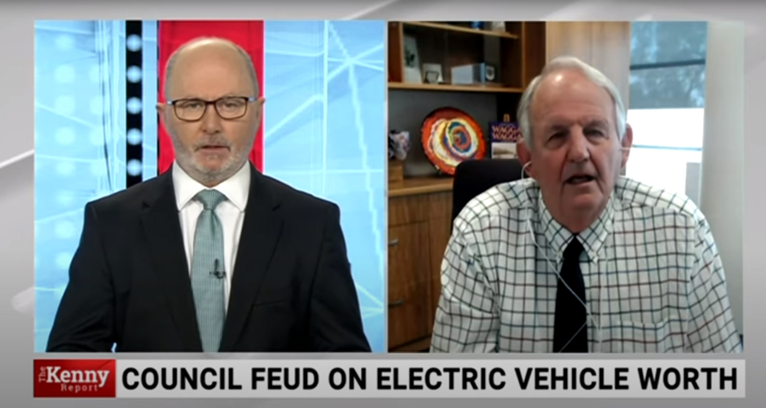 Screenshot of a splitscreen TV broadcast with bald man in suit on left and older man in shirt on right 