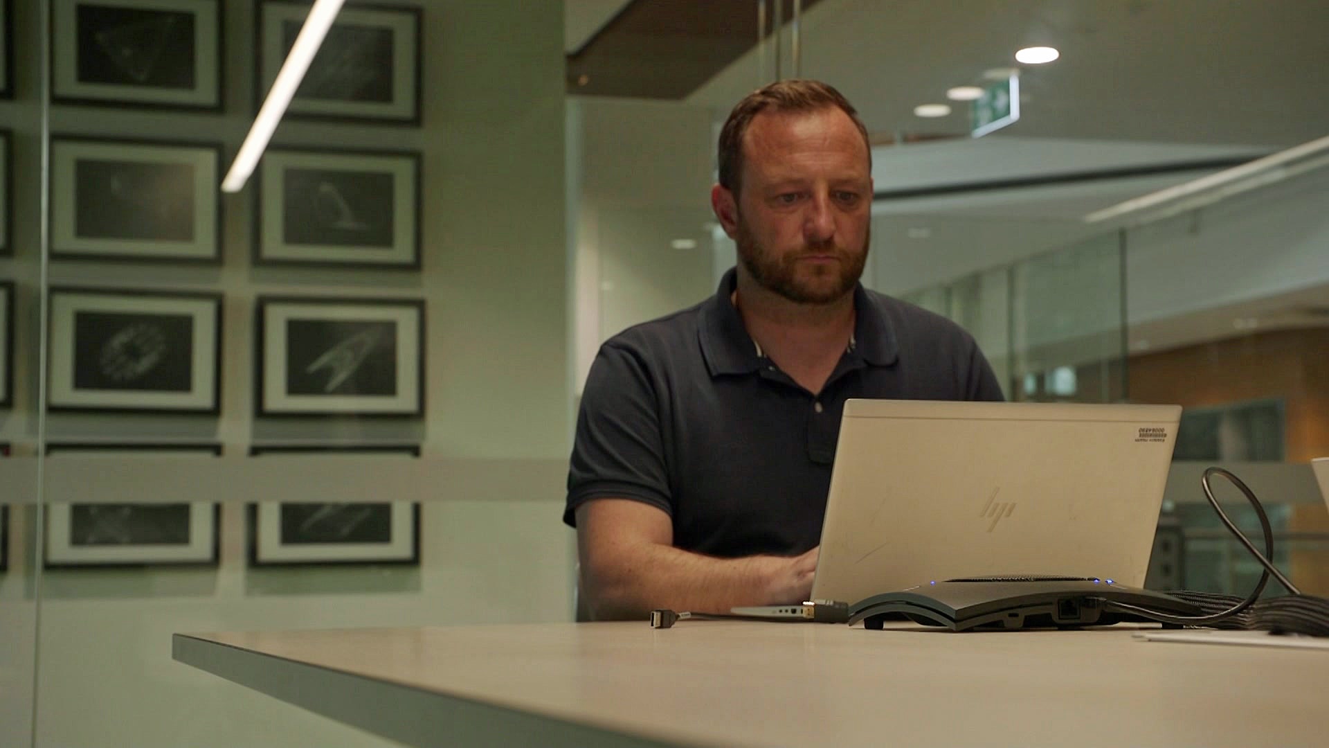 A man sits looking at his laptop
