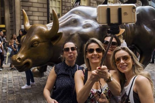 Tourists pose with Wall Street bull