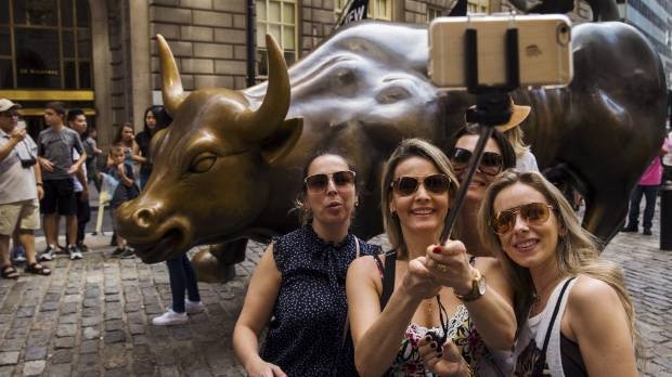 Tourists pose with Wall Street bull