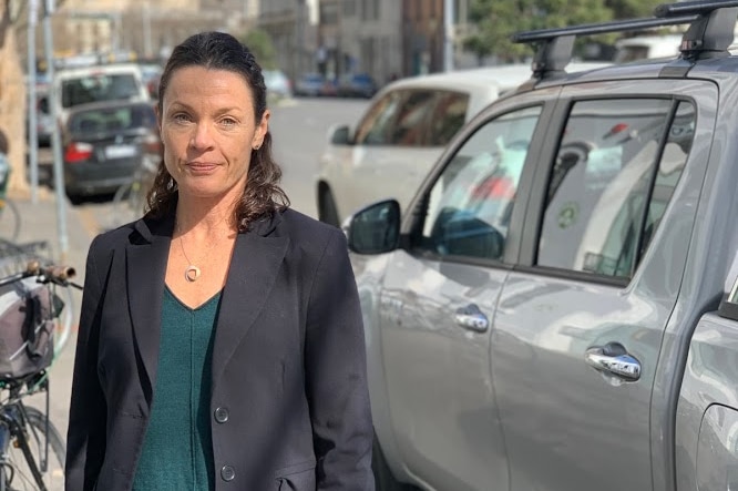 Australian Conservation Foundation campaigner Suzanne Harter stands between a bike and a Hilux.