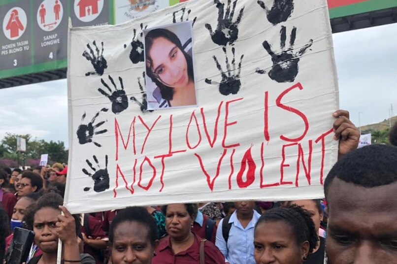 A sign with a picture of Jenelyn's face on it, reading 'my love is not violent'