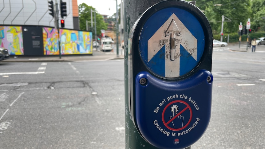 A close-up of the pedestrian cover that says "do not push the button"