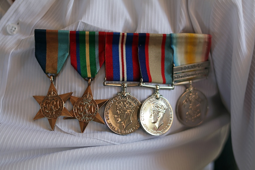 Keith Norton's medals pinned to his shirt.