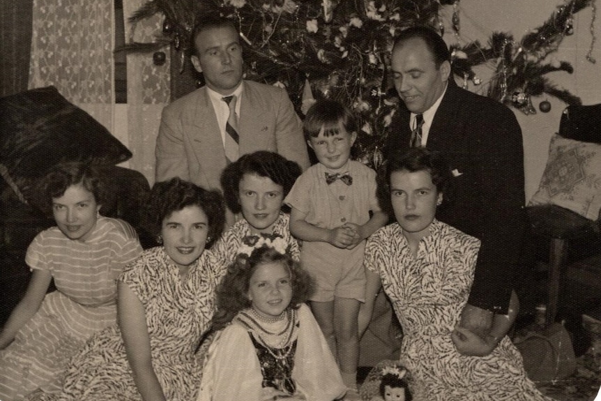 Black and white photograph of a white family smiling at camera