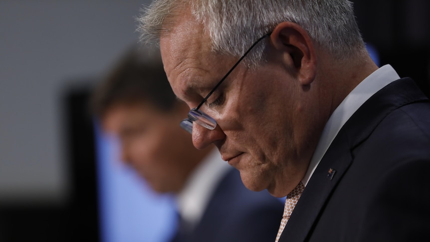 Scott Morrison looks down during a press conference 
