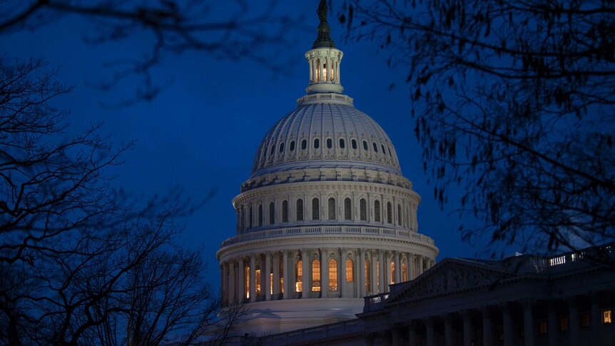 The US Capitol building illuminated at dusk