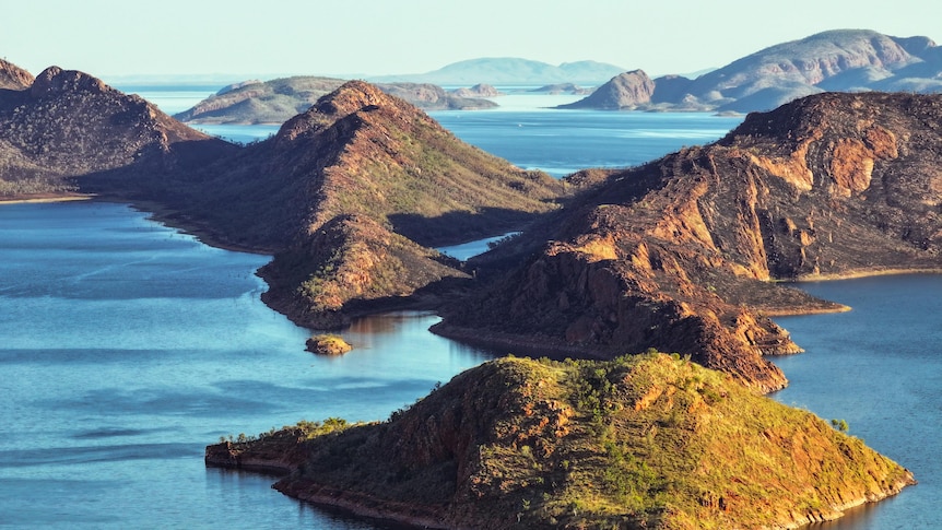 Rugged, greenery-covered islands in a blue lake, extending into the distance. 