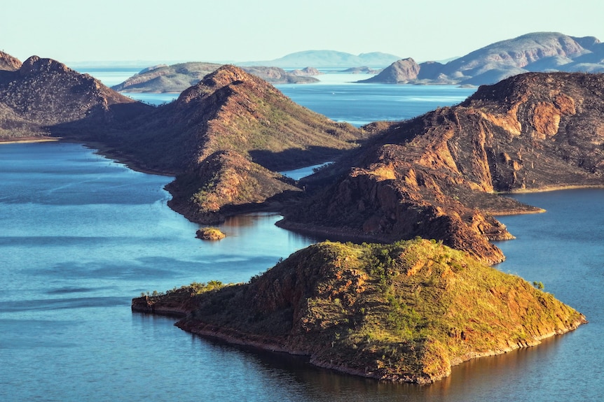 Rugged, greenery-covered islands in a blue lake, extending into the distance. 